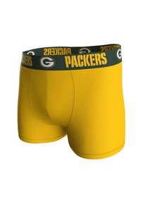 Žluté boxerky s zeleným elastickým pasem, na kterém je nápis "PACKERS" a logo. Hladká textura, přiléhavý střih a bez viditelných vzorů.