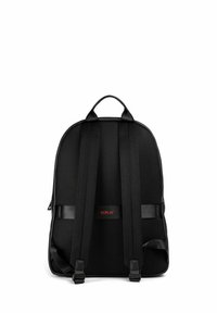 Sac à dos noir avec un dos en maille texturée, des bretelles rembourrées, une poignée supérieure et un logo rouge. Design simple et épuré.