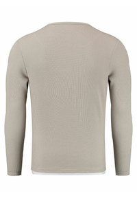 Lange mouwen geribbelde shirt in lichtgrijs. Heeft een zachte textuur, ronde hals en een subtiel geweven patroon op de stof.