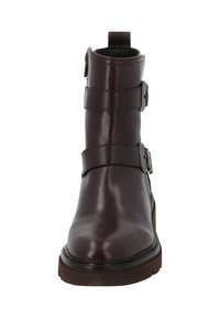 Stivale in pelle marrone fino alla caviglia con tre cinturini regolabili, punta arrotondata, tacco sottile e suola texturizzata, completo di un pratico passante per facilitarne l'indossamento.