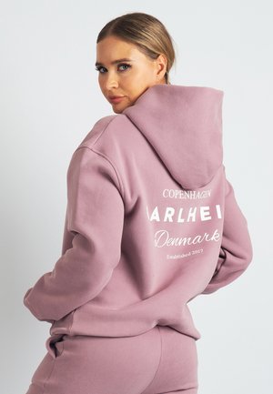 Pink hoodie made of soft material, featuring a hood and white text on the back reading "Copenhagen" and "Denmark Established 2017."