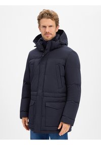 Marineblauwe pufferjas met capuchon, voorzien van een ritssluiting en drukknoopsluiting, twee voorzakken, doorgestikt ontwerp en elastische manchetten voor warmte.