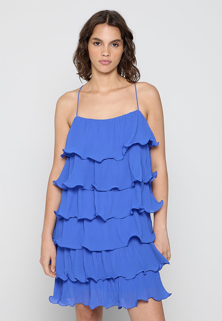 Blaues Schichtkleid mit Rüschenschichten, dünnen verstellbaren Trägern und einem leichten, strukturierten Stoff.