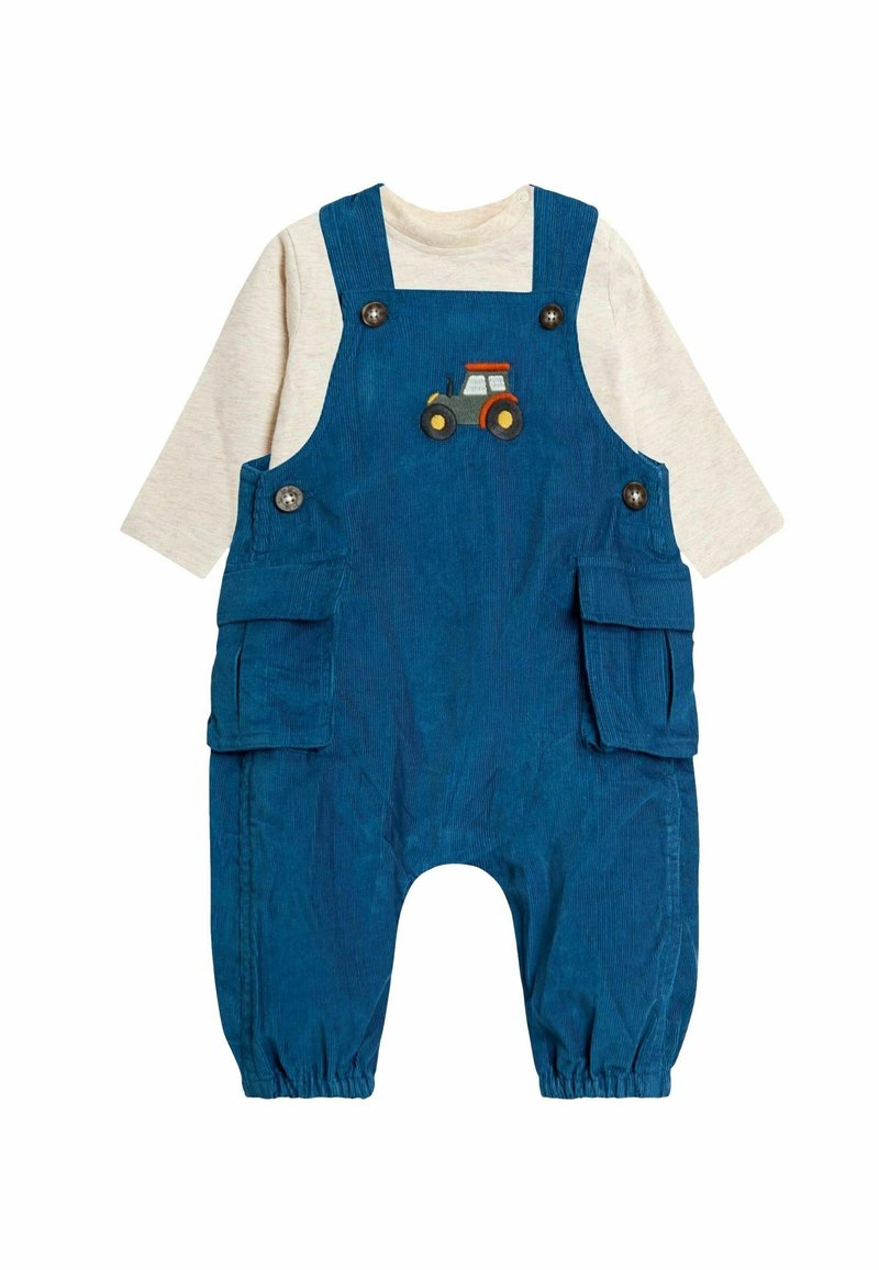 Zili corduroy kopumi ar divām sānu kabatām, ar traktora dizainu krūšdaļā, apvienoti ar gaiši bēšu garām piedurknēm krekliņu zemāk.