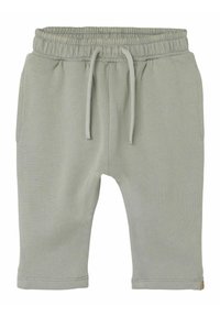 Shorts in cotone verde chiaro con vita elastica e coulisse, dotati di due tasche laterali e una superficie liscia.