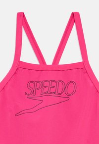 Ροζ τοπ μαγιό με λεπτές τιράντες, στρογγυλή λαιμόκοψη και μαύρο λογότυπο "SPEEDO" με ένα αεροδυναμικό γραφικό. Λείο ύφασμα.