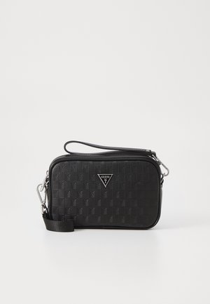 Zwarte rechthoekige crossbodytas met een textuur van vierkant patroon, zilverkleurige hardware, een ritssluiting aan de bovenkant, polsbandje en het Guess-logo middenvoor.