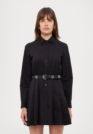 Svart knäppklänning med långa ärmar, figurnära bodice, utsvängd kjol och ett svart skärp med silverfärgad hårdvara och cirkulära detaljer.