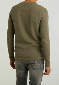 Olivgrünes, langärmeliges strukturiertes Strickshirt mit Rundhalsausschnitt und geripptem Saum. Die Rückansicht zeigt eine taillierte Form und minimale Details.