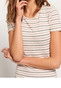 Randig t-shirt med kort ärm i ljus krämfärg med svarta och röda ränder, rund halsringning, ribbat mönster, kroppsnära passform och mjukt tyg.