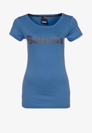 Sininen t-paita, joka on valmistettu puuvillasta, lyhythihaisilla ja pyöreällä kaula-aukolla. Suuri musta "Bench." -logo painettuna etupuolelle.