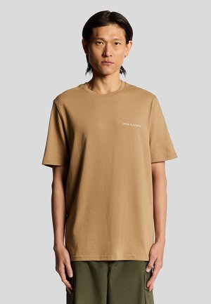 Beige Baumwoll-T-Shirt mit kurzen Ärmeln, Rundhalsausschnitt und kleinem weißen Logo auf der Brust. Einfaches Design, lockere Passform, glatte Textur.