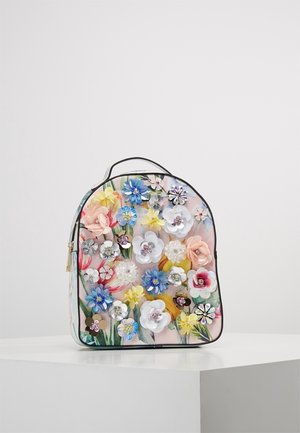 Kleine rugzak met pastelkleurige bloemenprint en 3D meerkleurige bloemapplicaties, ritssluiting en zwarte rand, tentoongesteld op een wit voetstuk.