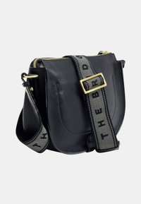 Borsa a tracolla in pelle nera con ampia tracolla regolabile, caratterizzata da testo nero e fibbia dorata, chiusura con zip dorata.