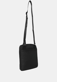 Borsa a spalla nera realizzata in tessuto resistente. Forma rettangolare con tracolla regolabile e tasca esterna con zip. Texture liscia, design minimalista.