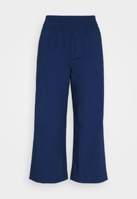 Marineblauwe wijde broek van lichtgewicht stof, met een elastische tailleband en een gladde textuur zonder zichtbare patronen of accenten.