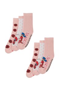 Quattro paia di calzini rosa: due con motivi di coccinelle, uno con pois e uno con un personaggio dei cartoni animati, tutti realizzati in tessuto morbido.