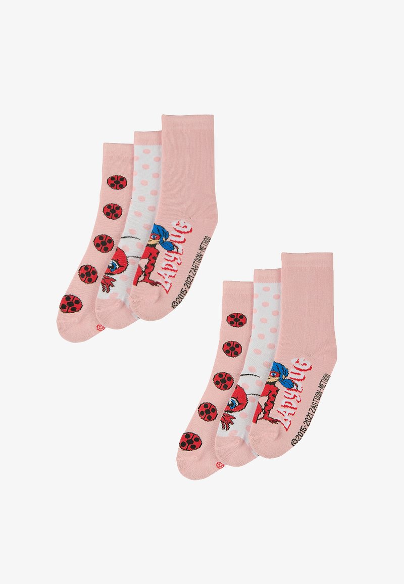 Vier Paar pinke Socken: zwei mit Marienkäfer-Motiven, eine mit Punkten und eine mit einem Cartoon-Charakter, alle aus weichem Stoff gefertigt.