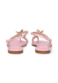 Sandalias planas rosas con un diseño de tiras finas, decoradas con acentos dorados y detalles en forma de mariposa en la parte trasera. Suela plana marrón.