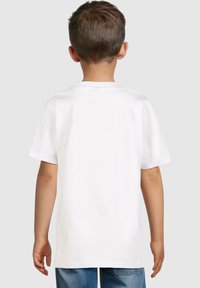 Camiseta blanca de manga corta vista por la parte posterior, hecha de algodón, con un cuello redondo y una textura suave. Ajuste casual.