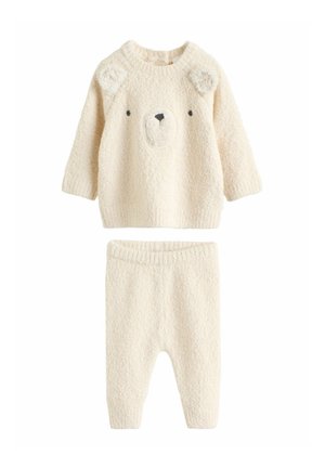 Tenue pour bébé en maille douce couleur crème avec un haut à manches longues orné d'un visage d'ours et un pantalon assorti avec une ceinture élastique.