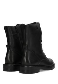 Czarne skórzane buty wojskowe z gładką teksturą, z wiązaniem i zamkiem, mające trwałą podeszwę oraz subtelne logo z boku.