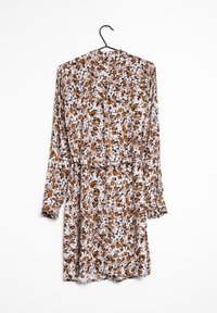 Květinové šaty s dlouhými rukávy, nařasenými manžetami a vázacím pasem. Tkanina má lehkou texturu s kombinací hnědých, bílých a černých květin.