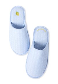 Pantofole azzurre con tessuto testurizzato, piccoli punti bianchi e un design di limone ricamato. Il testo dorato recita "ZEST D'AMOUR."