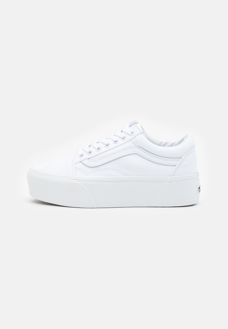 White canvas sneakers with a thick rubber sole, rounded toe, flat lace closure, and side stripe detail. Uniform color and smooth texture.