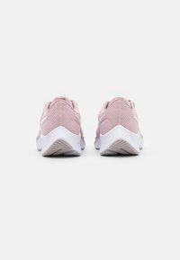 Zapatillas deportivas rosas con parte superior de malla texturizada, cuello acolchado y suela de goma blanca con patrones de banda de rodadura intrincados.