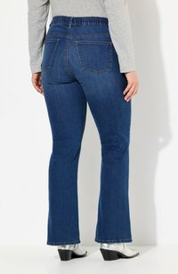 Siniset farkut, joissa on leveä lahje ja teksturoitu pinta, stretching-vyötärö ja kaksi takataskua. Helma on hieman repeytynyt.