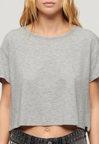 Lichtgrijze cropped t-shirt van een zachte katoenmix, met een ronde halslijn en korte mouwen. Geen zichtbare patronen of graphics.