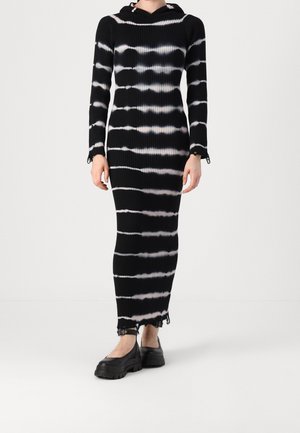 Schwarz-weißes Batik-Rippstrickkleid mit Kapuze, langen Ärmeln und Raffung an den Handgelenken, mit enger Silhouette und ausgefranstem Saum.