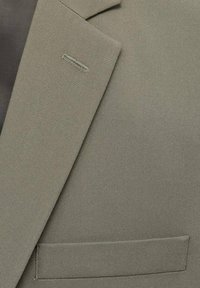 Light gray suit jacket featuring a smooth texture, notch lapels, single-button closure, and a welt pocket with clean stitching.