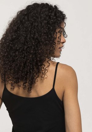 Schwarzes Tanktop mit dünnen Trägern, das ein tailliertes Design und eine glatte Textur aufweist. Lockige Haare verdecken teilweise die Schulter aus seitlicher Sicht.