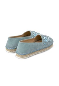 Blauwe suede espadrilles met bloemenversieringen, open zijkanten, jute gevlochten zolen en contrasterende blauwe stiksels langs de randen.