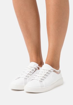 Bílé šněrovací tenisky s hladkým, texturovaným povrchem, s průhlednými akcenty na bocích a zaobleným designem špičky.