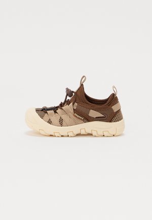 Brune atletiksko med meshlag, gummisåler og elastiske snørebånd. Har en glat beige tåhætte og teksturerede detaljer på overdelen.