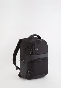 Mochila negra hecha de un tejido texturizado con un acento de tipo cuero suave. Presenta múltiples compartimentos con cremallera y correas de hombro acolchadas.