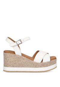 Sandalias de plataforma blancas con una cuña de color beige de textura trenzada, que cuentan con correas cruzadas y una correa ajustable en el tobillo. Parte superior de cuero suave.
