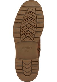 Hnědá guma podrážky boty s cik-cak vzorem, odvodními otvory a logo "GEOX ITALIAN PATENT" vytlačené na povrchu.