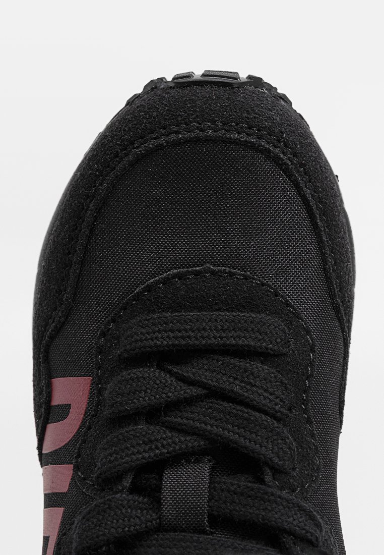 Schwarzer Sportschuh von vorne mit strukturiertem Zehenbereich und dicken schwarzen Schnürsenkeln, mit teilweise bordeauxfarbigem Text an der Seite.