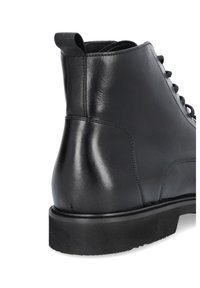 Czarne skórzane botki za kostkę z zaokrąglonym noskiem, gładką teksturą, sznurowanym przodem i grubą gumową podeszwą. Posiadają pętelkę do zakładania na pięcie.
