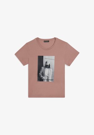 Camiseta de algodón rosa con un estampado gráfico en blanco y negro y el texto "HOY ES TU DÍA" en la parte inferior. Mangas cortas, escote redondo.