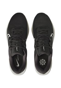Un par de zapatillas de running Nike negras con logotipos blancos de swoosh, cordones grises y suelas intermedias blancas, vistas desde arriba sobre un fondo blanco.
