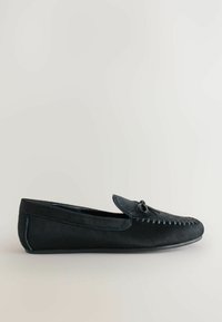 Musta nahkainen loaferi, jossa on pyöreä kärki, koristeelliset tikkaus, litteä pohja ja nauha-aksentti edessä. Tasainen pinta kauttaaltaan.