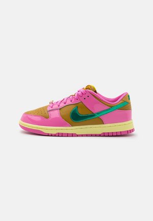 Baskets Nike présentant un mélange de matériaux rose, brun et vert, avec un col rembourré, un bout arrondi et une semelle en caoutchouc texturée.