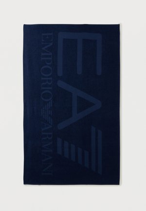 Tengerészkék törölköző, nagy, diszkrét "EA7" betűkkel és az "Emporio Armani" logóval, amely függőlegesen fut a szélén.