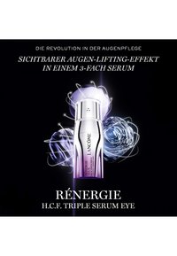 Lancôme Rénergie H.C.F. Triple Serum Eye-Fläschchen hervorgehoben mit leuchtenden abstrakten Kugeln vor schwarzem Hintergrund, bewirbt den straffenden Effekt für die Augen.