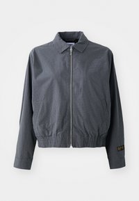 Grå rutete bomberjakke, lett stoff, glidelåslukking, krage, elastisk kant, sidelommer og kontrasterende logodetalj på erm.